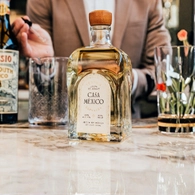 Bottle of Casa Mexico Reposado Tequila next to some glassware